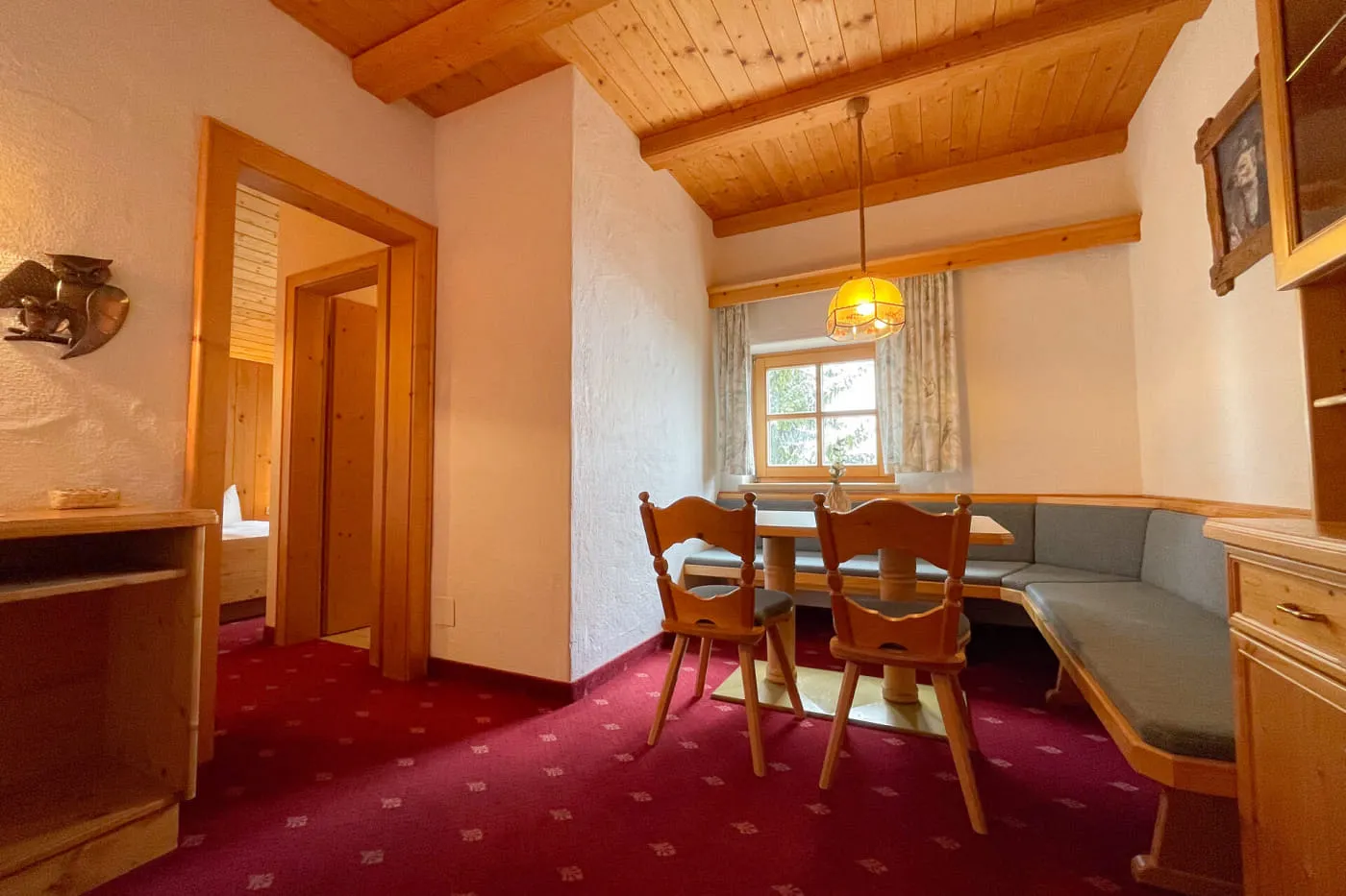 Geräumige Sitzecke im Ochsalm Zimmer mit Eckbank, Esstisch und Holzdecke